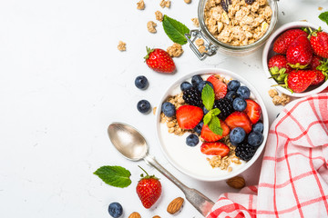 Greek yogurt granola with fresh berries on white table.