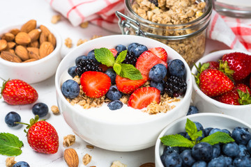Greek yogurt granola with fresh berries on white table.