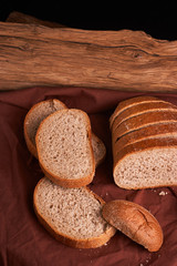 Bakery - gold rustic crusty loaves of bread and buns on black chalkboard background. Still life captured from above
