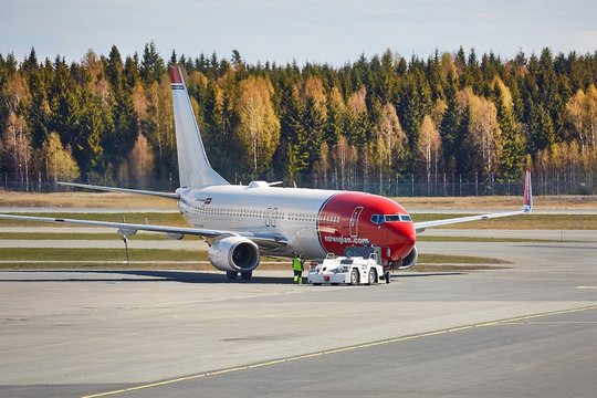 OSLO, NORWAY - MAY 3, 2015: Airliner of Norwegian Air Shuttle taxiing at Oslo Gardermoen airport. Pushed back by towtruck