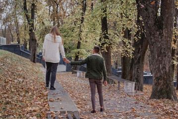 Fototapeta premium Happy young couple walking on a autumn day in the park.They are having fun together. cute teenager