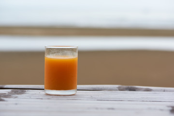 A glass of tasty orange juice on wooden table