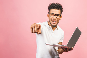 Happy winner! Portrait of happy young afroamerican man using laptop comruter and checkin isolated...