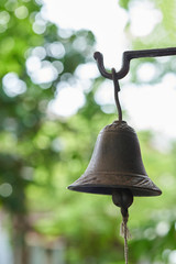An old hand bell hanging on the door