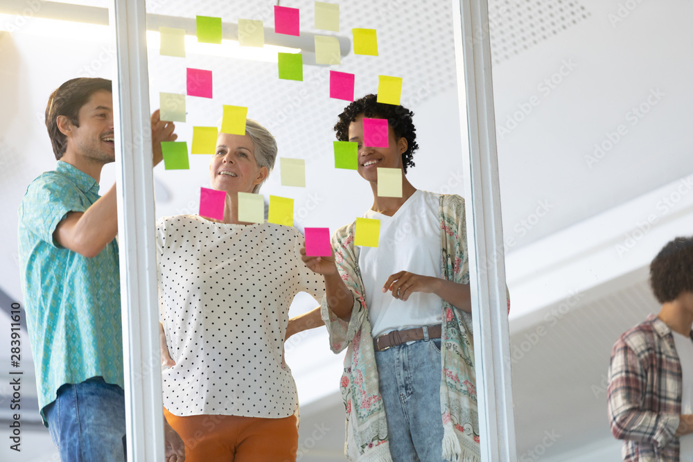 Wall mural Business people discussing over sticky notes in the office