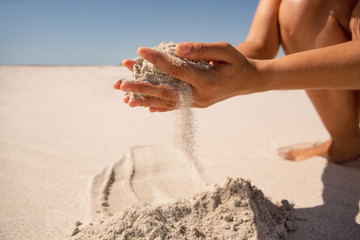 Woman playing with sand on the beach
