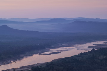 Obraz premium Mountain view morning of Peak mountain above mekong river around with soft mist and cloudy sky background, sunrise at Cha Na Dai Cliff, Pha Taem National Park, Ubon Ratchathani, Thailand.