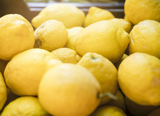 Lot of bright yellow lemons in supermarket