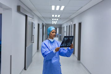 Female surgeon examining x-ray in the corridor of hospital