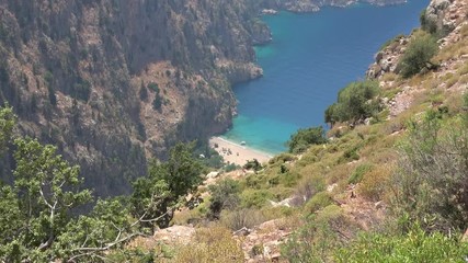 Above the Butterfly Valley, Fethiye, Turkey - 12th of June 2019: 4K View on the beach of the Butterfly Valley from the mountain above, zoom out