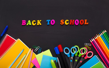 Colored Back to school text with stationery on chalk board