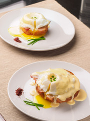 Breakfast is Eggs Benedict - toasted English muffins, bacon, ham, poached eggs, herbs and delicious buttery hollandaise sauce.