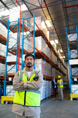 Fototapeta na wymiar Male worker standing with arms crossed and looking at camera in warehouse