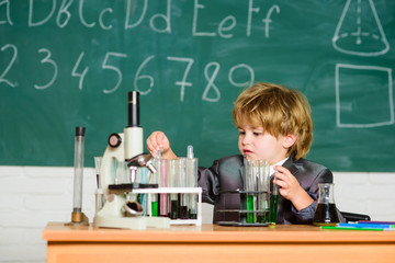 Knowledge concept. Knowledge day. Inspiration for investigations. Kid study biology chemistry. Boy microscope and test tubes school. Basic knowledge primary school education. Educational experiment