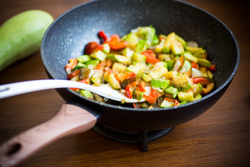 fried zucchini with red pepper, onions, tomatoes and other vegetables