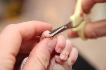 Fingernägel schneiden bei einem Neugeborenem 