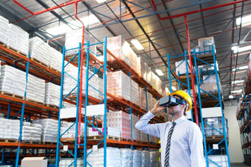 Male supervisor using virtual reality headset in warehouse