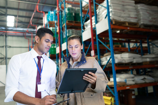 Warehouse staffs discussing over digital tablet in warehouse