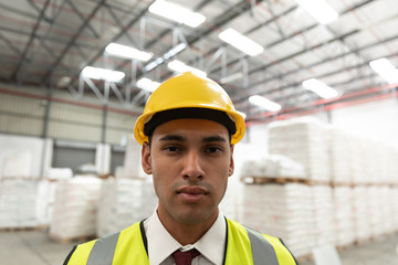 Male worker looking at camera in warehouse