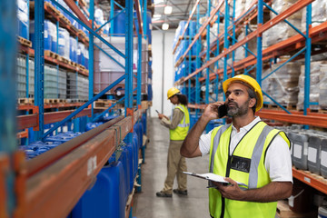 Male worker talking on mobile phone in warehouse