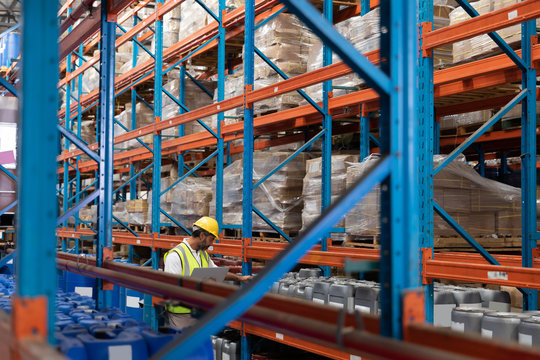 Male worker checking stocks in warehouse