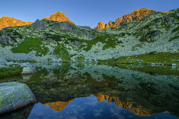 Mountain landscape and glacial Taul Portii lake in Retezat National Park, Carpathian Mountains, Romania, at sunrise