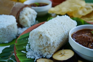 Kerala breakfast rice Puttu /Pittu made in bamboo mould served with Kadala curry banana papad and tea on banana leaf