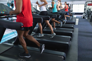 Fototapeta na wymiar Fit people exercising on treadmill in fitness center