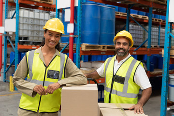 Male and female worker looking at camera in warehouse