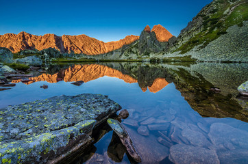 Mountain landscape and glacial Taul Portii lake in Retezat National Park, Carpathian Mountains, Romania, at sunrise