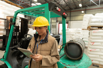 Female worker working on digital tablet in warehouse