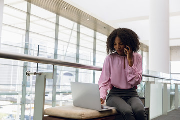 Young businesswoman working in the lobby of modern office