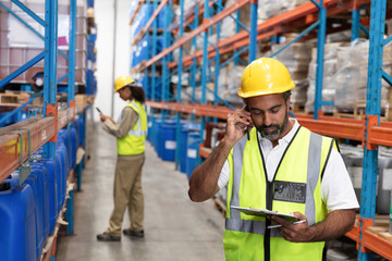 Male worker talking on mobile phone in warehouse