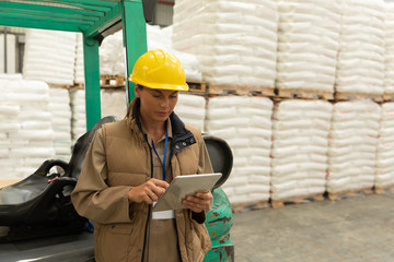 Female worker using digital tablet in warehouse