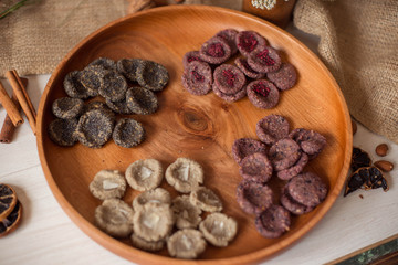 Assortment of sweets without sugar and gluten on a wooden dish. Dessert made from healthy natural ingredients. Beautiful composition of healthy diet candies and flowers