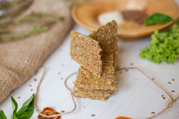 Crispbread tightened by a rope. Healthy food on a white background besid the ingredients in a wooden plate. .Lettuce with carrot near bread cakes