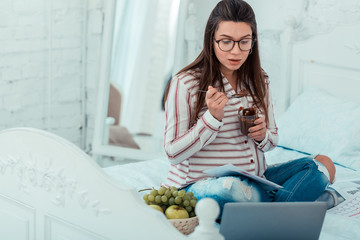 Enigmatical pregnant female watching video about pregnancy