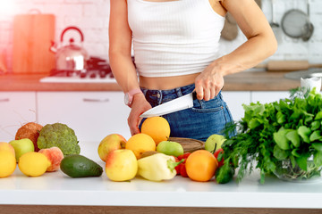 Young woman preparing tasty lemonade in kitchen. Detox diet. Healthy Nutrition