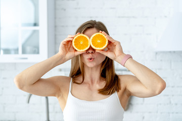 Young woman preparing tasty lemonade in kitchen. Detox diet. Healthy Nutrition