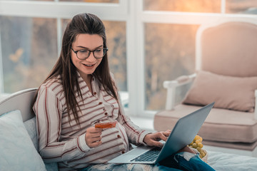 Charming pregnant female person being at home