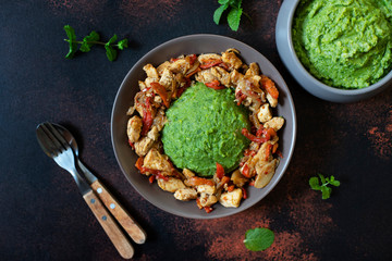 Mashed potatoes with green peas and corn served with chicken and vegetable stew. African cuisine, Kenyan cuisine, a traditional dish called mukimo. Top view, copyspace