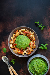 Mashed potatoes with green peas and corn served with chicken and vegetable stew. African cuisine, Kenyan cuisine, a traditional dish called mukimo or irio. Top view, copyspace, vertical