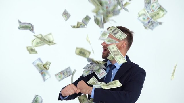 Slow motion of formally dressed man performs a victory dance, and a lot of dollar bills are fall on him