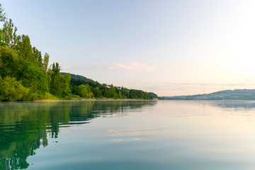 view of the lake at dawn early in the morning, the shore overgrown with trees