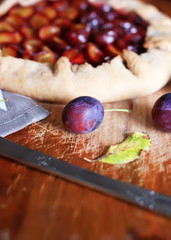 Galette with plums on a wooden table. Plum sweet homemade pie