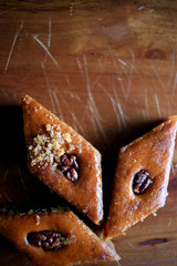 Traditional oriental dessert is a baklava with walnuts, on a wooden table. Turkish baklava
