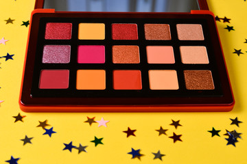 Eye shadow palette on orange background. Copy space.