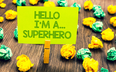 Fototapeta premium Handwriting text Hello I am A ... Superhero. Concept meaning Special powers Cartoon character Customs strenght Paperclip retain written words yellow paper paper lobs laid on wooden floor