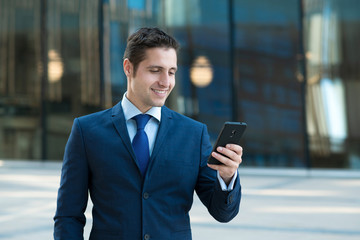 Happy young businessman get good news on phone outdoor the glass bulding