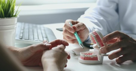dentist and patient talking about planned teeth treatment in dental clinic office - Powered by Adobe